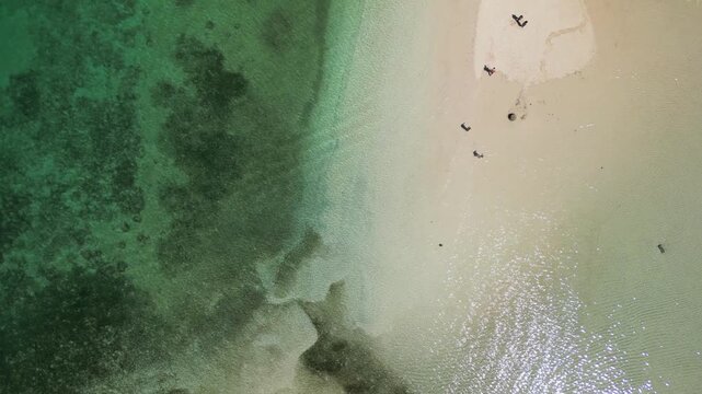 Stunning overhead view Gili Kere Lombok sand tongue with white sandbar coral reef lush greenery and sunny seascape horizon
