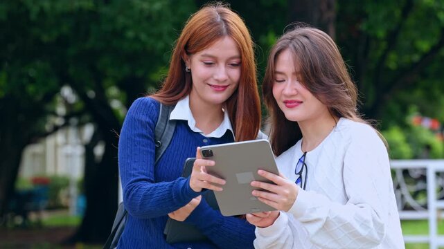 Student woman on college campus with tablet notebook backpack, conversation outdoor education scene, friendly learning moment near tree walkway fence in park