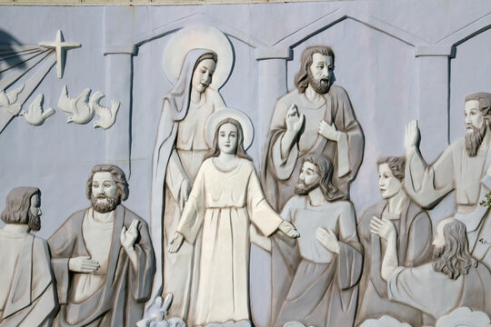 NHA TRANG, VIETNAM: A large stone wall relief carving depicting the biblical story of the Young Jesus Christ with the Virgin Mary at the city cathedral.