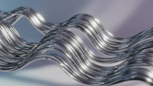 Flowing metallic silver wave threads with shiny surfaces against a blurred background in a studio