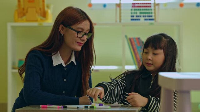 Teacher child classroom learning writing education tutor student desk marker guide focused girl during lesson with calm adult support, homework activity in bright school room