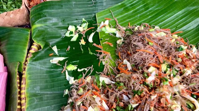 preparing traditional indonesian stir fried glass noodles on banana leaf