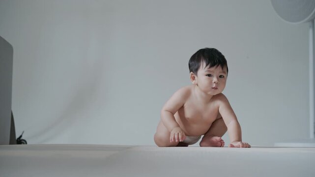 4K Cute Asian baby boy crawling on the floor and smiling happily.