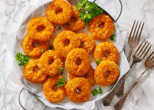 Golden Breaded Cheese Wheels On Paper on a tray
