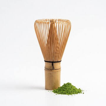 Isolated dead-center shot of a traditional Japanese bamboo chasen whisk with a pile of matcha powder.
