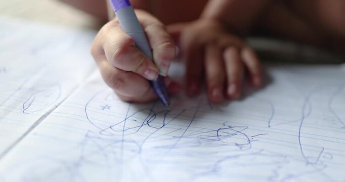 Child drawing in a notebook with a pen, creativity and learning, child development, education, imagination, fine motor skills, and early childhood, close-up