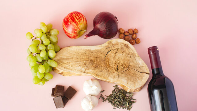 Products containing polyphenols in their composition. Grapes, onions, garlic, chocolate, tea, nuts, apple close-up on a light background, evenly layered