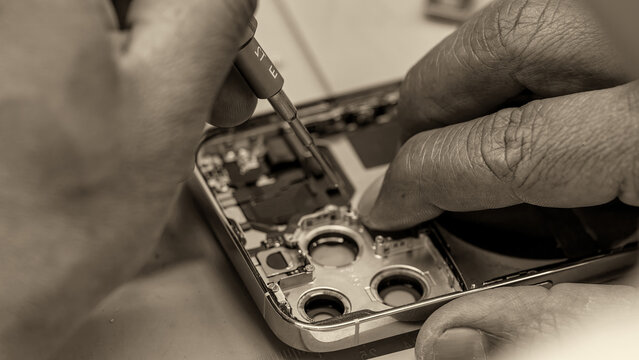 Close-up view of disassembled smartphone revealing internal motherboard components in repair lab