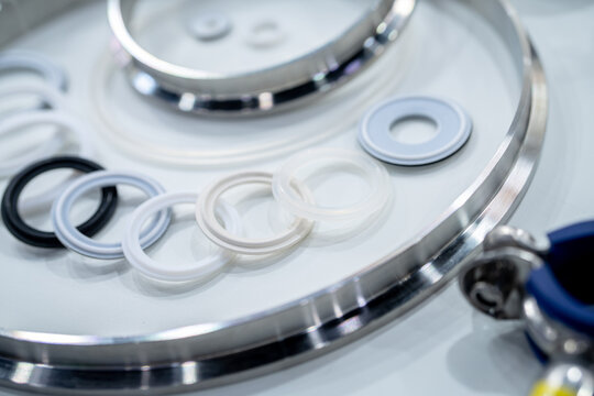 Industrial gasket and sealing rings arranged on stainless steel surface in manufacturing. Precision engineering, material quality, and components used for mechanical assembly and industrial systems.