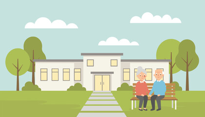 Naklejka premium Happy senior couple holding hands while sitting on a wooden bench in front of a modern nursing home or hospital building.