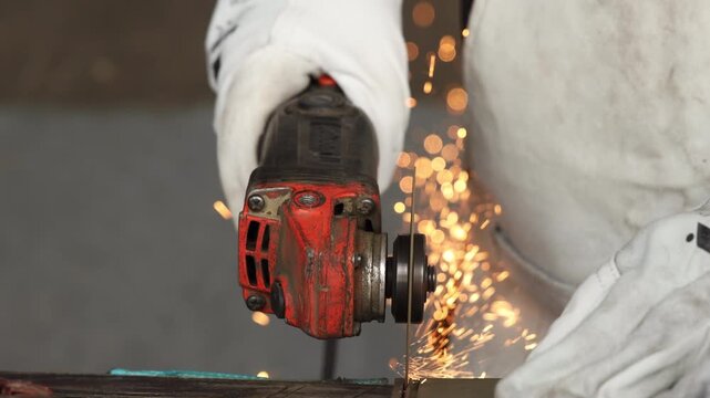 Macro shot of glowing orange sparks and light trails during steel cutting process
