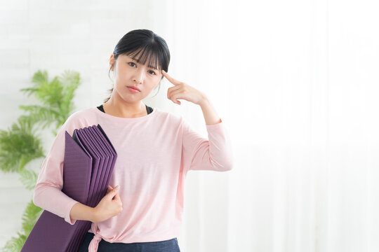 考えるヨガウェアの若い女性