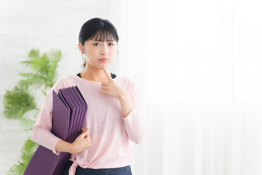 考えるヨガウェアの若い女性