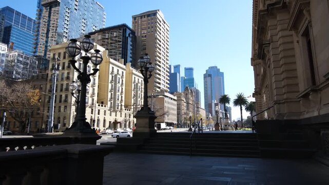 Old Treasury Building overlooking ornate lampposts and Spring Street in Melbourne's CBD, Australia. Modern skyscrapers rising beyond heritage architecture. Coexisting of old and new
