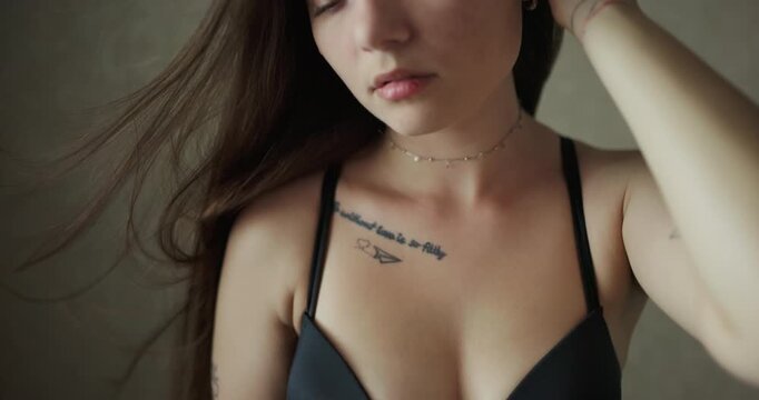 Detailed shot of girl cleavage and neck with choker under wind flow in slow motion