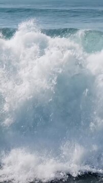 Captivating video of large turquoise ocean waves crashing with white foamy spray in natural bright daylight setting