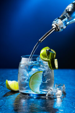 Vodka with lime and ice cubes in a fogged up glass.