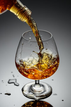 The amber-gold strong alcoholic beverage is poured into a glass.