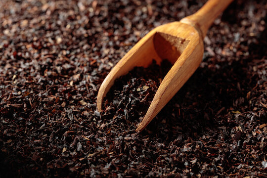 Dried fermented tea leaves and small wooden spoon.