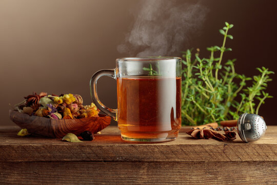 Herbal tea with ingredients on a old wooden table.
