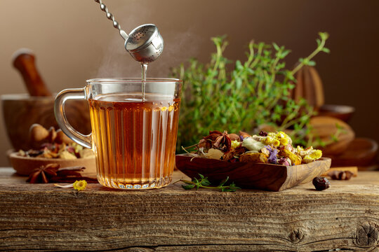 Herbal tea with ingredients on a old wooden table.
