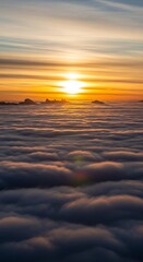 Obraz premium Bright sun glowing through clouds over sea of mist.