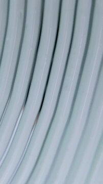 Vertical close up of creating striped texture on beauty cream using a comb-like tool. Smooth cream transformed into lined pattern for artistic skincare concept.