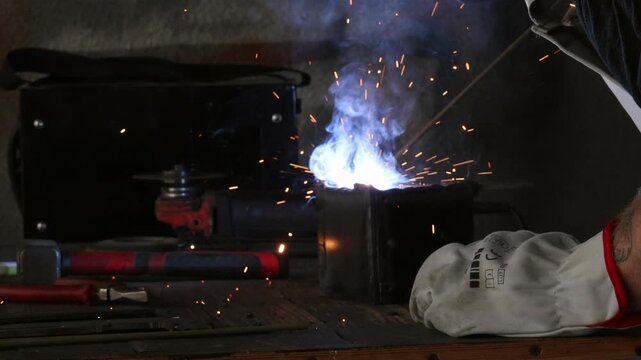 Selective focus on arc welding process with hot sparks and dark low key background