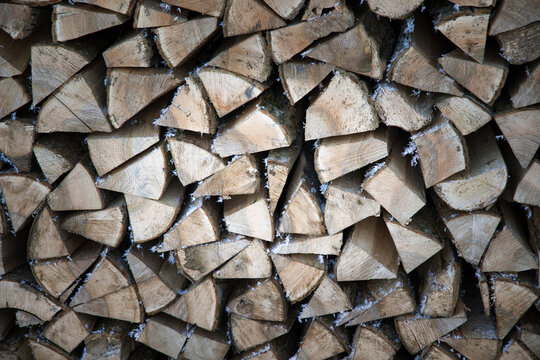 Rustic Stacked Firewood Logs Covered with Delicate Hoarfrost Crystals in Winter