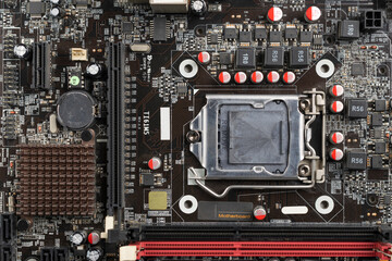 Fototapeta premium Close-up top view of a computer motherboard with CPU socket, electronic components, and circuits.
