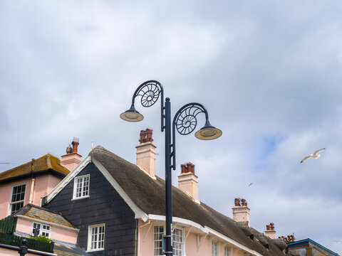 Lamppost in the town of Lyme Regis, featuring an amonite fossil shape highlighting the richness of fossil finds in the area, Jurassic Coast, Dorset, England