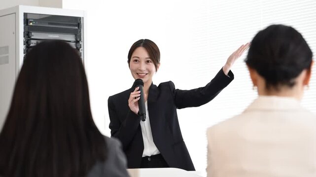 プレゼンテーションで説明をする20代から40代の日本人ビジネスパーソン3人