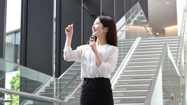 ピンマイクを持ってプレゼンテーションをする20代の日本人女性