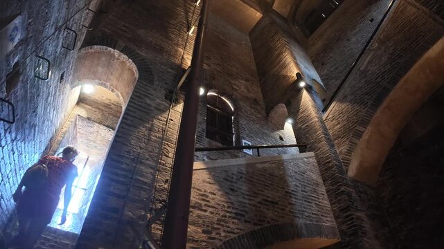 tourist woman on the stairs of the panoramic view inside the Ghirlandina bell tower, showcasing the striking architecture of Modena's revered Duomo cathedral of Modena city in Italy