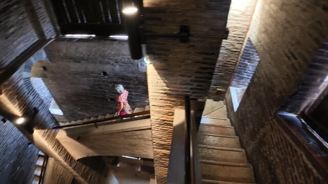 Breathtaking view of tourist woman inside the Ghirlandina bell tower of the Modena cathedral, showcasing its medieval architecture and complex structure of Modena city in Italy
