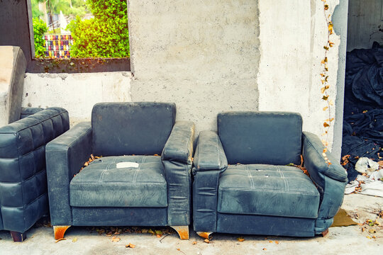 old abandoned house front with black sofa