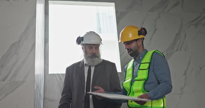 Engineer and businessman inspecting ceramic tile sample at house construction renovation site