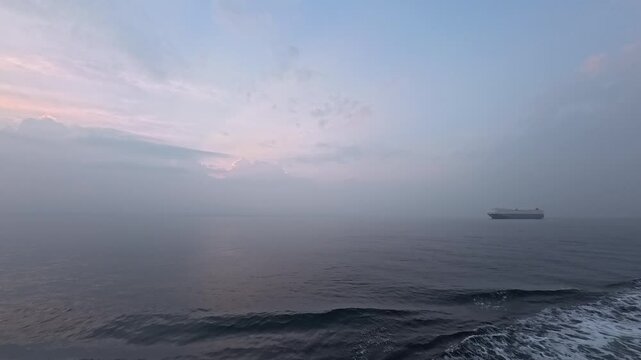 Stunning maritime logistics footage featuring a vehicle carrier ship silhouette in the misty horizon