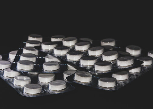 A blister pack of white paracetamol pills tablets with isolated on a neutral background