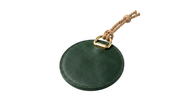 Round dark green leather keychain with metal ring and rope detail on transparent background.