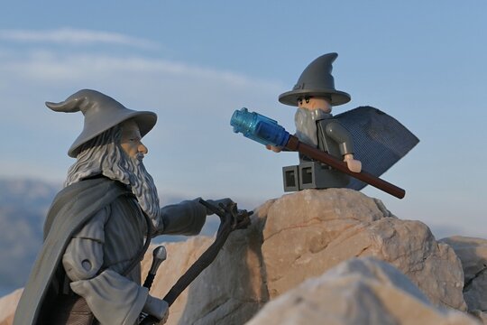 Action figure of wizard Gandalf The Grey from novels Hobbit and Lord Of The Rings by J.R.R.Tolkien meets small version of blocks made Gandalf  figure on the beach coastal rocks in Croatia. 