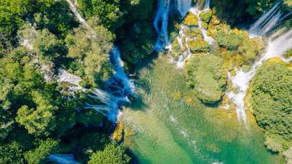 Top down aerial view of cascading waterfalls flowing into emerald pools © Sanja