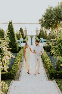 Couple enjoys a romantic stroll in a beautiful garden by the water
