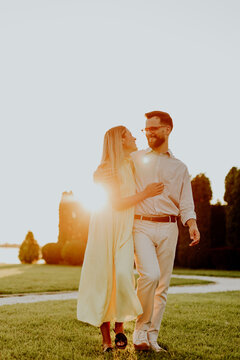 Couple walks together during sunset at a park near a water body