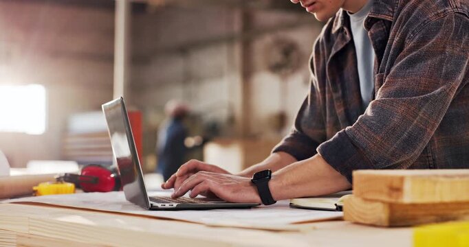 Hand, carpenter and reading in factory with laptop, research and review design for production. Man, typing and pc in workshop for carpentry, online blueprint and schedule for manufacturing furniture