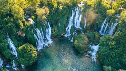 Spectacular aerial panorama of cascading waterfalls surrounded by dense forest © Sanja