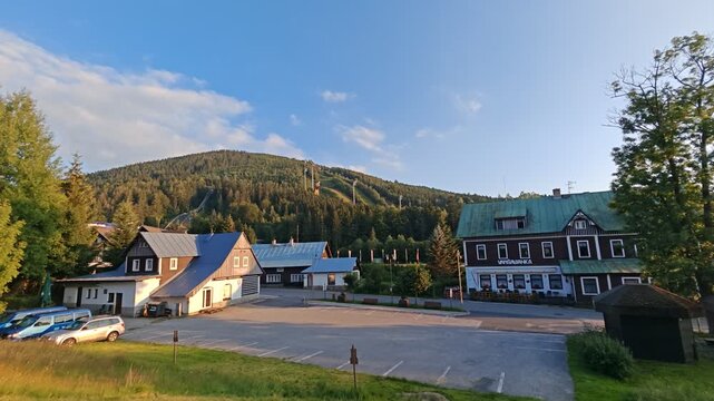 Historic center of Harrachov with traditional buildings and forested mountain slopes in the background