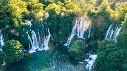 Majestic cascading waterfalls surrounded by untouched green forest © Sanja