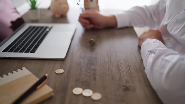 Close-up of businessman's hand spinning one euro coin on wooden office desk, symbolizing decision-making, financial risk, investment choices, chance and business uncertainty