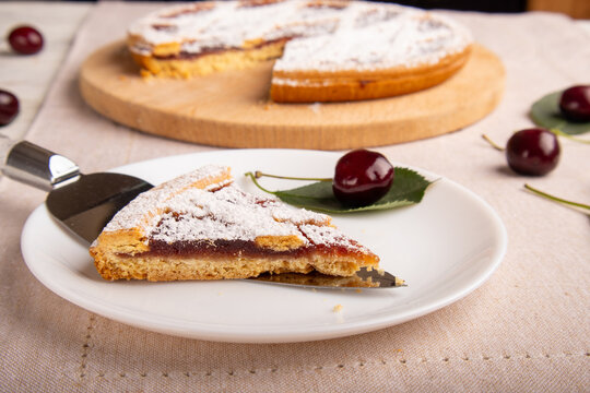 Cherry Pie Slice on Plate with Whole Pie in Background